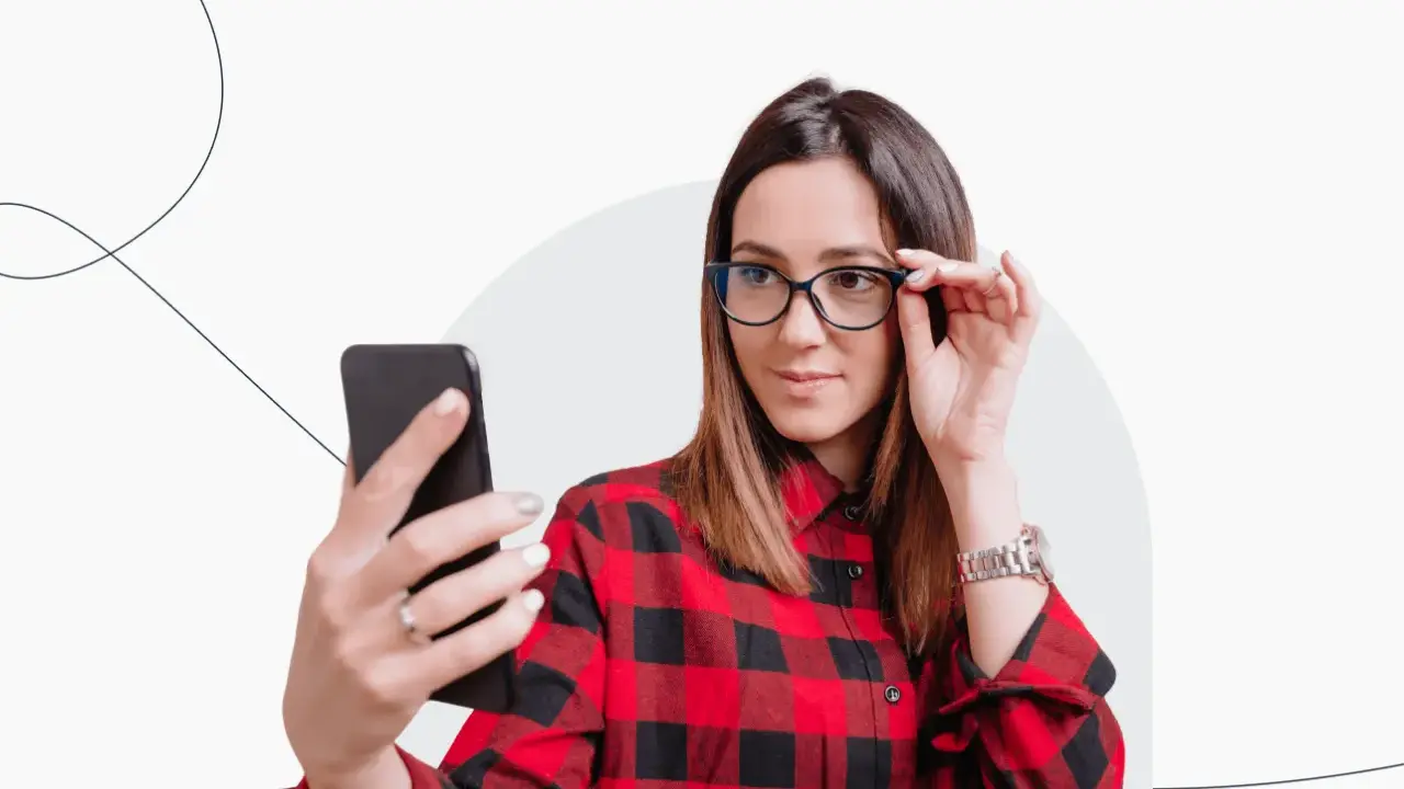 Kobieta w okularach robi selfie telefonem, zastanawiając się, czy na zdjęciu do dowodu można mieć okulary.