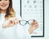 Okulista prezentuje okulary podczas badania wzroku.
