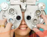 Badanie optometryczne: pacjent uśmiecha się, gdy optometrysta reguluje soczewki refraktora.