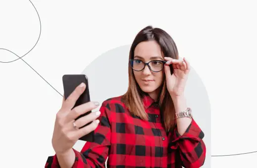 Kobieta w okularach robi selfie telefonem, zastanawiając się, czy na zdjęciu do dowodu można mieć okulary.