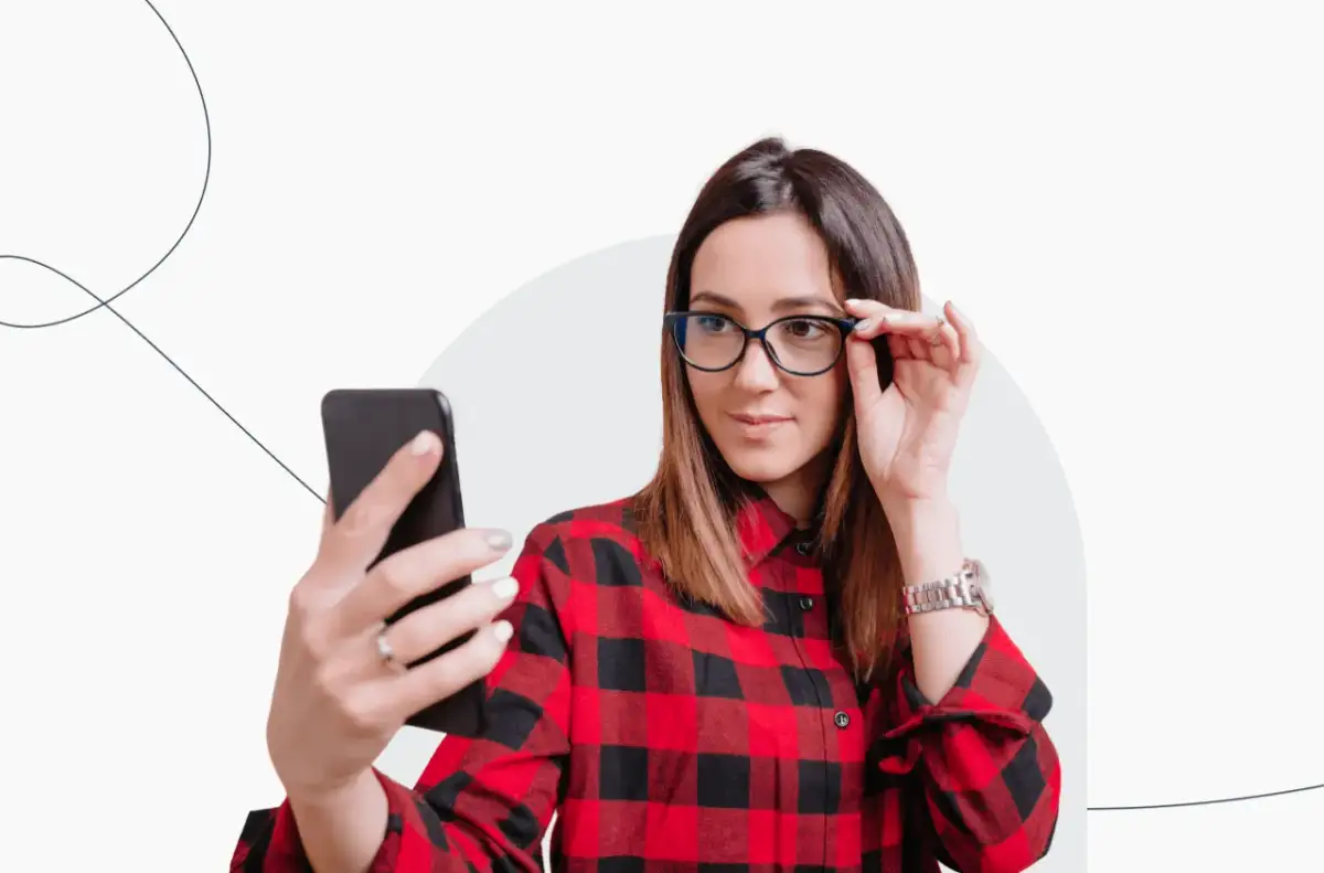 Kobieta w okularach robi selfie telefonem, zastanawiając się, czy na zdjęciu do dowodu można mieć okulary.